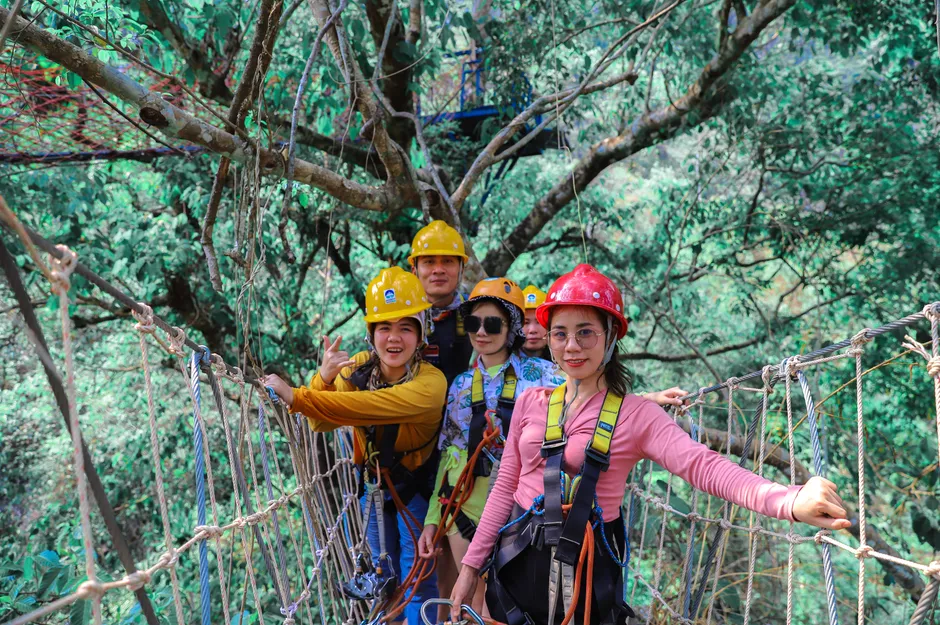 Du khách trải nghiệm zipline băng qua rừng tại khu du lịch